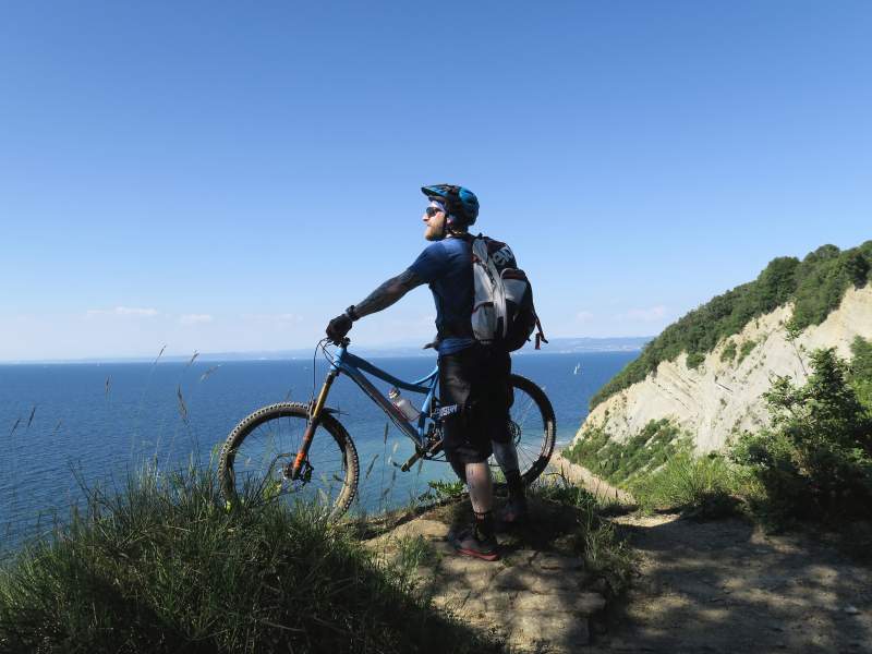 Biker steht am Meer - Ende des Alpencross am Meer