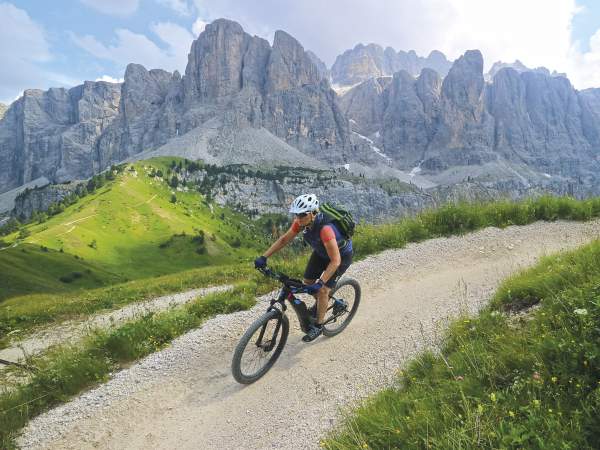 Frau mit E-Bike macht leichten Alpencross in den Dolomiten
