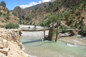 Mountainbiker überquert Fluss in Marokko