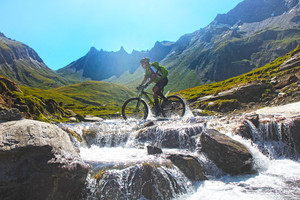 mountainbiker_durchquert_bach_bei_transalp_zum_pfundererjoch